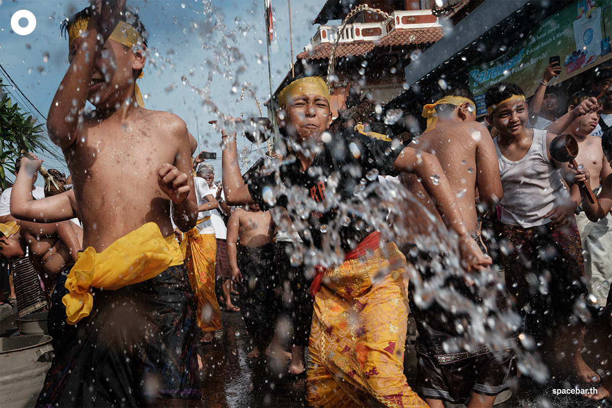 เด็กๆ ชาวบาหลีที่นับถือศาสนาฮินดูสาดน้ำใส่กันอย่างสนุกสนาน 1 วันหลังจากวันแห่งความเงียบ” หรือนิเยปิ (Nyepi) ซึ่งถือเป็นวันขึ้นปีใหม่ตามปฏิทินฮินดูของชาวบาหลี ถือเป็นวันหยุดทางศาสนาที่สำคัญสำหรับชาวฮินดูบนเกาะอีก 1 วัน Photo by Yasuyoshi CHIBA / AFP 