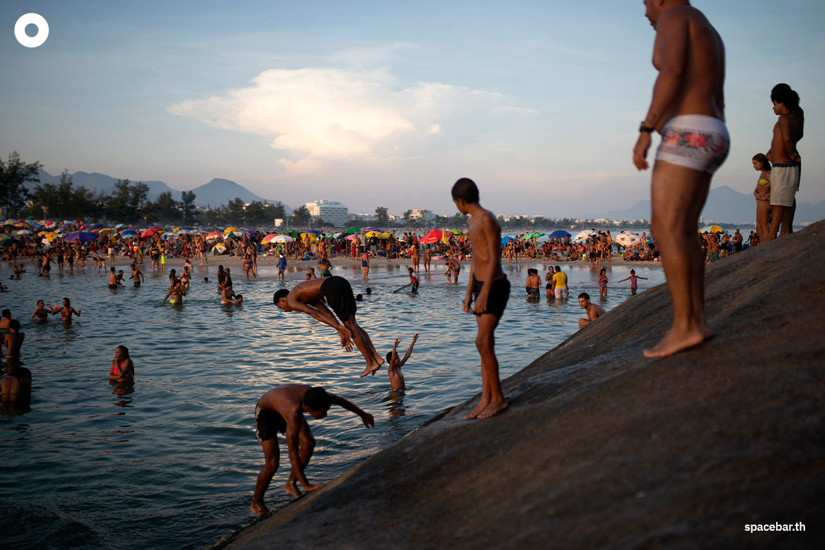 ผู้คนกำลังเพลิดเพลินกับการเล่นน้ำทะเลบริเวณชายหาด เรเซอีโอ โดส บันเดรันเตส (Recreio dos Bandeirantes) ท่ามกลางคลื่นความร้อนในเมืองรีโอเดจาเนโร ประเทศบราซิล เมื่อวันที่ 17 มีนาคม 2024 (Photo by TERCIO TEIXEIRA / AFP) 