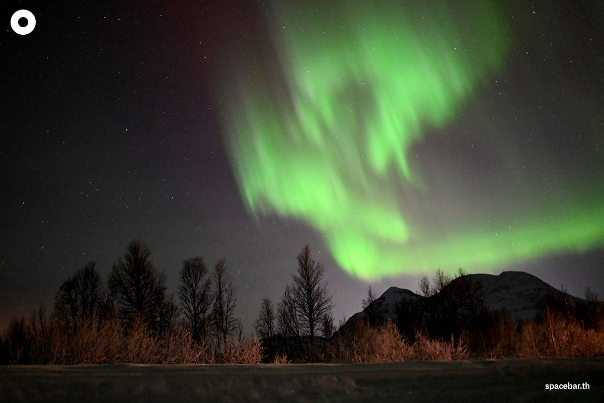 ภาพลำแสงเหนือ (Aurora Borealis) ส่องสว่างบนท้องฟ้าเหนือบริเวณแคมป์ชนพื้นเมืองซามิ (Sami) นอกหมู่บ้านเบรวิคเคเดต (the village of Breivikeidet) ใกล้เมืองทรอมโซ ประเทศนอร์เวย์ เมื่อวันที่ 1 มกราคม 2024 (Photo by Sergei GAPON / AFP) 