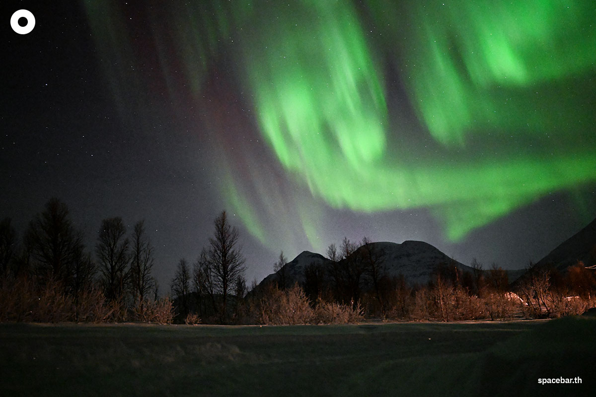 ลำแสงเหนือ (Aurora Borealis) กำลังส่องสว่างบนท้องฟ้าเหนือบริเวณแคมป์ชนพื้นเมืองซามิ (Sami) นอกหมู่บ้านเบรวิคเคเดต (the village of Breivikeidet) ใกล้เมืองทรอมโซ ประเทศนอร์เวย์ เมื่อวันที่ 1 มกราคม 2024 (Photo by Sergei GAPON / AFP) 