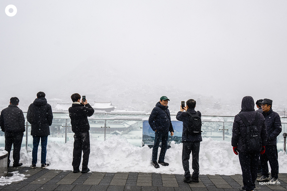 ผู้คนพากันถ่ายรูปบนระเบียงของพระราชวังคยองบกกุงท่ามกลางหิมะแรกของฤดูหนาวปีนี้ที่ตกหนักเป็นประวัติการณ์ในรอบ 117 ปี Photo by ANTHONY WALLACE / AFP