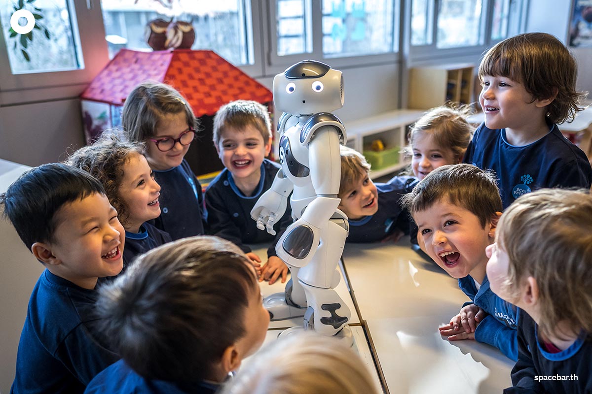 เด็กอนุบาลชาวสวิสกำลังพูดคุยโต้ตอบกับ ‘นาโอะ’ (robot Nao) หุ่นยนต์เพื่อการศึกษาและการสื่อสารโต้ตอบที่ศูนย์เด็กก่อนวัยเรียน ‘ลา นองออสแฟร์’ ในวิทยาเขตของสถาบันเทคโนโลยีแห่งสหพันธ์สวิส เมืองโลซาน สวิตเซอร์แลนด์ (Photo by Fabrice COFFRINI / AFP)
