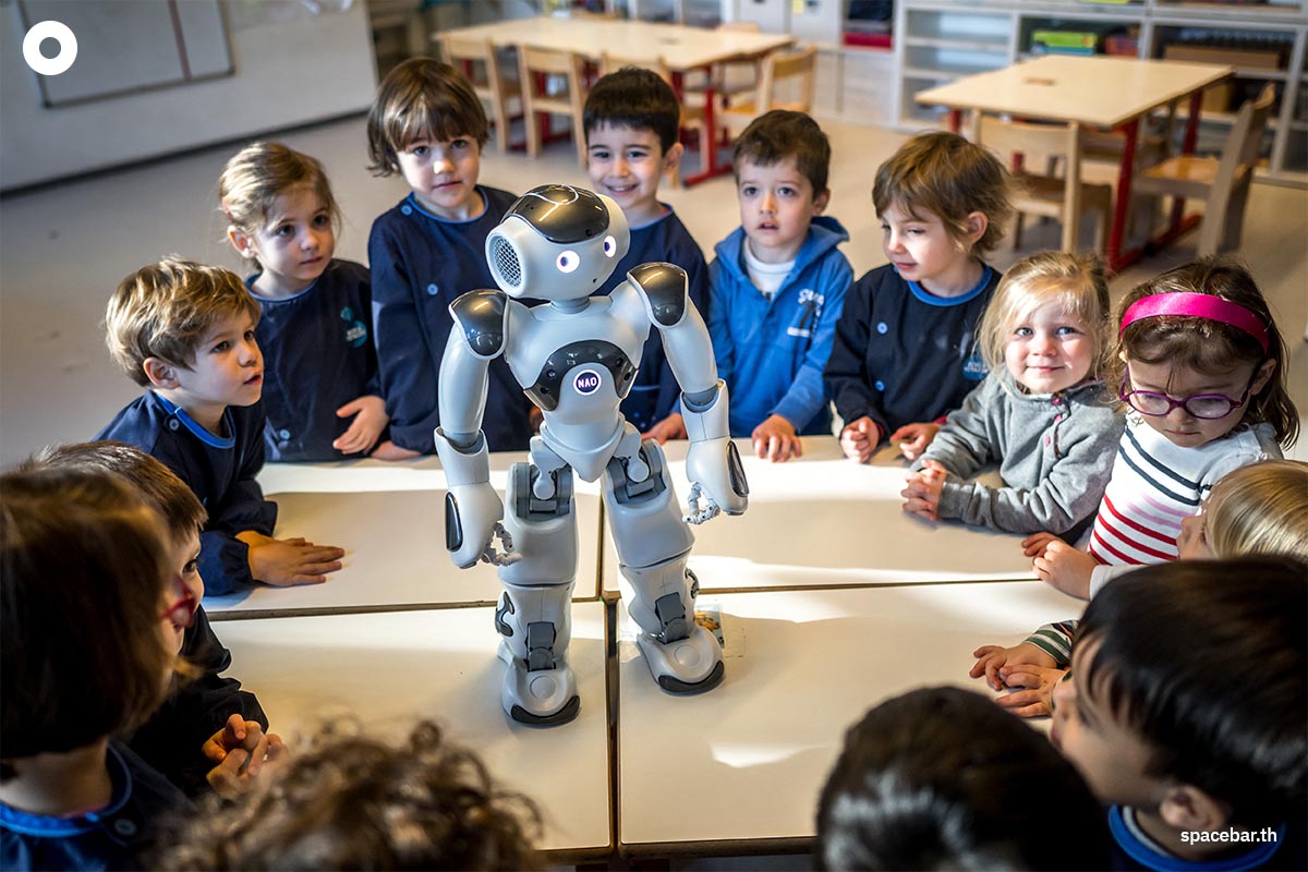 เด็กอนุบาลชาวสวิสกำลังพูดคุยโต้ตอบกับ ‘นาโอะ’ (robot Nao) หุ่นยนต์เพื่อการศึกษาและการสื่อสารโต้ตอบที่ศูนย์เด็กก่อนวัยเรียน ‘ลา นองออสแฟร์’ ในวิทยาเขตของสถาบันเทคโนโลยีแห่งสหพันธ์สวิส เมืองโลซาน สวิตเซอร์แลนด์ (Photo by Fabrice COFFRINI / AFP)
